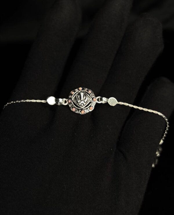 Antique Silver Floral Om Rakhi with Sparkling Pink Accents